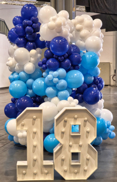 Organiczna dekoracja z balonów jako tło dla liczby 18 podkreślającej jubileusz półmaratonu w Poznaniu