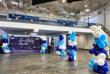 Trójkolorowe, organiczne kolumny z balonów jako dekoracje na hali MTP w Poznaniu z okazji 18 poznańskiego półmaratonu