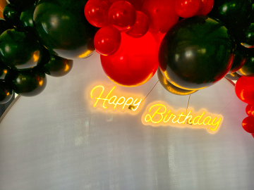 Neon urodzinowy Happy Birthday jako dekoracja ścianki zrobionej z balonów
