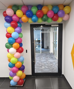 Kolorowa pół-brama z balonów jako dekoracja wejścia do nowego biura we Wrocławiu