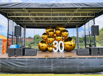 Dekoracja sceny balonami kulami XXL Złote balony kule lustrzane XXL jako dekoracja sceny na urodzinową imprezę firmową.