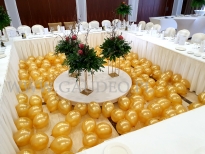 Złote balony z powietrzem jako dekoracja części bankietowej sali.
