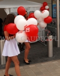 Balony z nadrukowanym logo sklepu założone na patyczki w czasie rozdawanie przez hostessy.