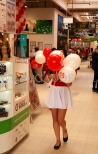 Balony z nadrukiem na patyczkach niesione przez hostessę.
