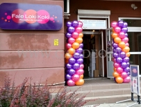 Kolorowe kolumny balonowe przed wejściem do sklepu.