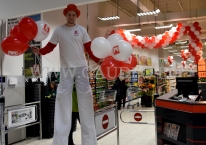Balony z logo rozdawane przez szczudlarza.
