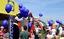 Balony z nadrukiem i helem w czasie rozdawania przez szczudlarzy.