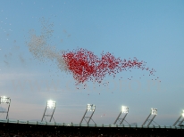 Balony z helem unoszące się po wypuszczeniu nad stadionem.