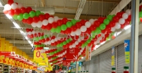 Girlandy balonowe nad kasami w hipermarkecie Auchan.