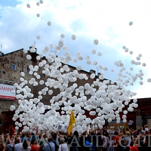 Zrzucane balony spadają na uczestników korowodu.