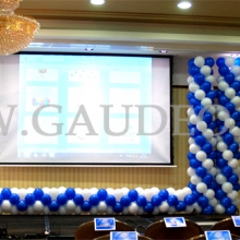 Balonowe girlandy dekorują scenę na konferencji firmowej.