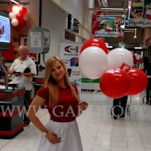 Balony reklamowe na patyczkach trzymane przez hostessę.