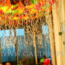 Balony z helem pod sufitem i balony z powietrzem na podłodze jako dekoracja imprezy firmowej.